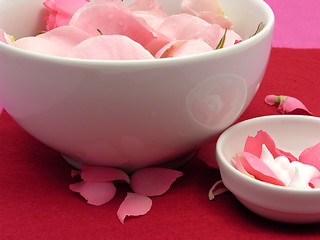 Image showing Pink roses and cream in  white bowls of chinaware on red background