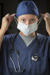 Image showing Female Doctor or Nurse Putting on Protective Face Mask