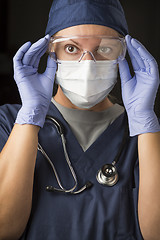 Image showing Female Doctor or Nurse Putting on Protective Facial Wear