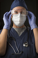 Image showing Female Doctor or Nurse Putting on Protective Facial Wear