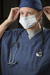 Image showing Female Doctor or Nurse Putting on Protective Face Mask