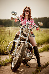 Image showing Biker girl sitting on motorcycle