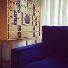 Image showing Wooden dresser and blue velvet armchair