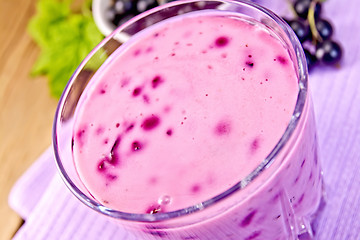 Image showing Milkshake with black currants in glass on board