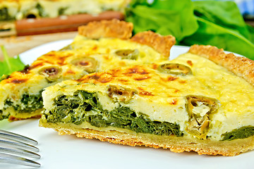 Image showing Pie with spinach and olives on plate