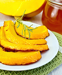 Image showing Pumpkin baked with honey in bowl on board
