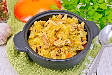 Image showing Cabbage stew with meat in black pot on napkin