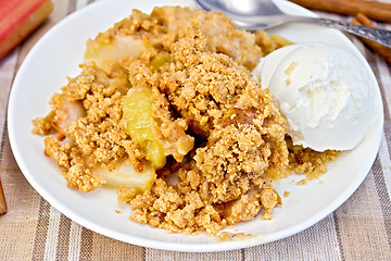 Image showing Crumble with rhubarb in dish on linen tablecloth