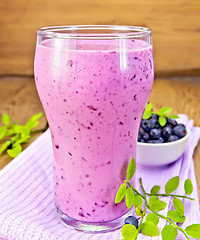 Image showing Milkshake with blueberries and napkin on board