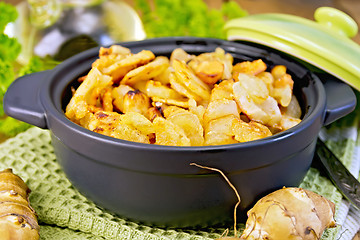 Image showing Jerusalem artichokes roasted in pan with lid on board