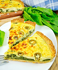 Image showing Pie with spinach and olives in plate on board