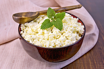 Image showing Curd in wooden bowl with spoon and mint on napkin