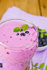 Image showing Milkshake with blueberries in glass on board
