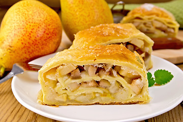 Image showing Strudel with pears and mint in bowl on board