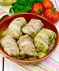 Image showing Cabbage stuffed with sauerkraut in ceramic pan on napkin