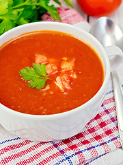 Image showing Soup tomato with parsley on napkin and spoon