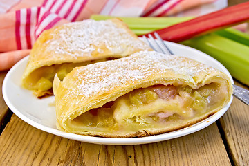 Image showing Strudel with rhubarb and fork in plate on board