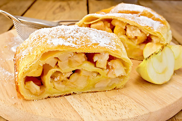 Image showing Strudel with apples and strainer on board