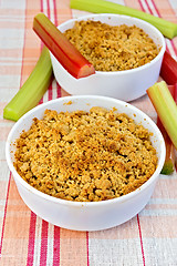 Image showing Crumble with rhubarb in two bowls on linen tablecloth
