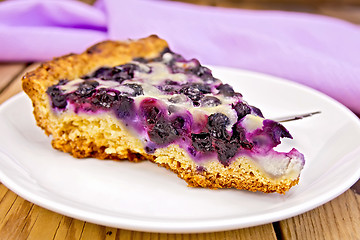 Image showing Pie with blueberries and spoon in plate on board
