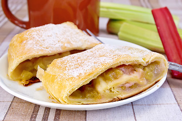 Image showing Strudel with rhubarb and mug on linen tablecloth