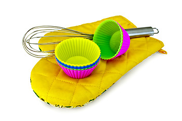 Image showing Molds for cupcakes with mixer on potholder