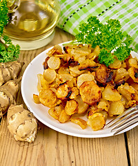 Image showing Jerusalem artichokes fried in dish with napkin on board