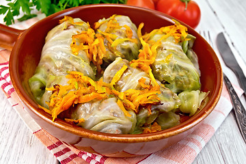 Image showing Cabbage stuffed with sauerkraut in ceramic pan on board