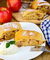 Image showing Strudel with apples and ice cream with napkin on board