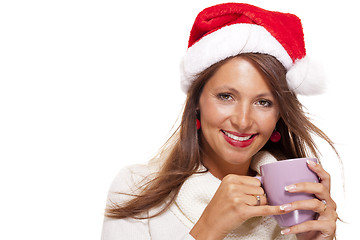 Image showing Cold young woman in a Santa hat sipping coffee tea