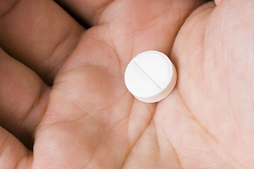 Image showing Single white pill in palm

