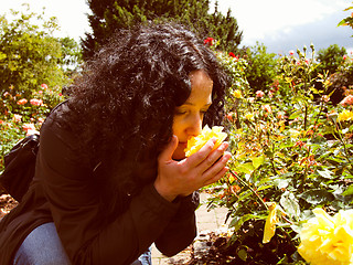 Image showing Pretty brunette smelling roses