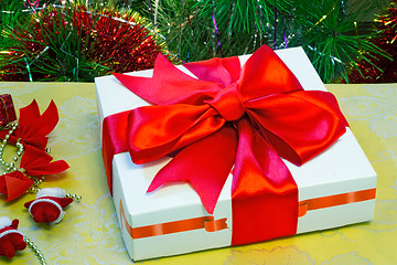 Image showing Beautifully packed gift by Christmas and the decorated fir-tree.