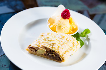 Image showing Apple strudel with icing sugar,almonds and vanilla ice cream