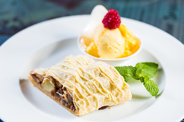 Image showing Apple strudel with icing sugar,almonds and vanilla ice cream