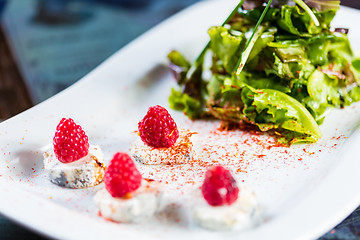 Image showing fresh salad with goat cheese and raspberry.