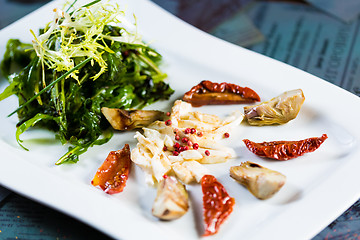 Image showing Fresh salad with sun-dried tomatoes and cheese in the Italian style.