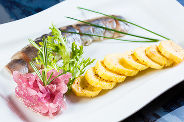 Image showing Herring with fried potatoes and red onions