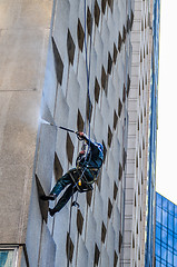 Image showing Washer wash the windows of modern skyscraper, high risk work