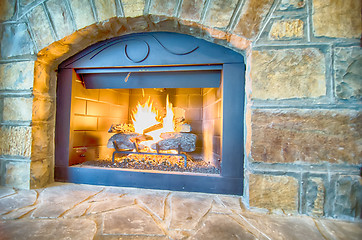 Image showing luxurious stone structure fireplace with burning fire