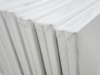 Image showing blank canvas or poster with pile of canvas 