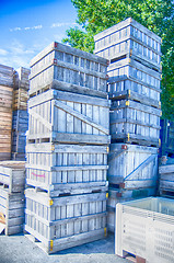 Image showing Stack of fruit boxes or crates sit outside a warehouse 