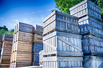 Image showing Stack of fruit boxes or crates sit outside a warehouse 