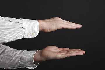 Image showing Caucasian male hands protect something