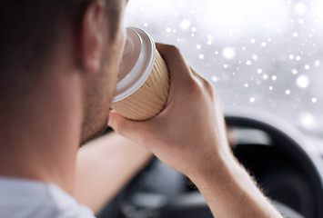 Image showing close up of man drinking coffee while driving car