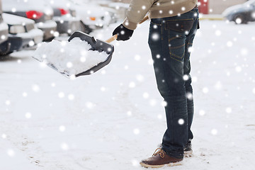 Image showing closeup of man digging snow with shovel near car