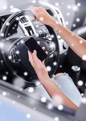 Image showing close up of woman with smartphone driving car