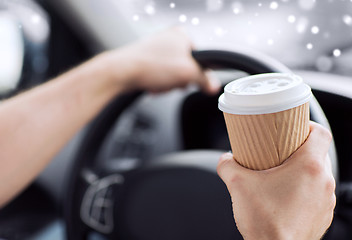 Image showing close up of man drinking coffee while driving car