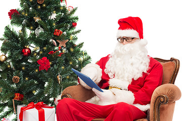 Image showing man in costume of santa claus with tablet pc