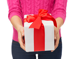 Image showing close up of woman in pink sweater holding gift box